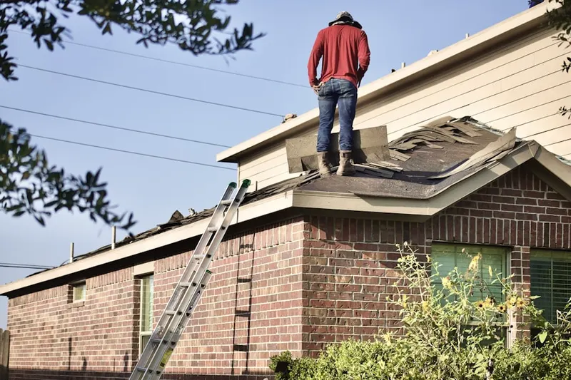 Professional roofer working on a residential roof in Mantachie